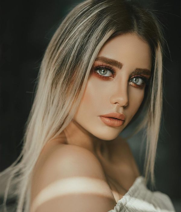 Young woman looking into distance with calm expression in neon blue lighting